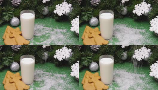 人造雪花飘落在圣诞饼干、一杯牛奶和圣诞装饰品上。给圣诞老人的圣诞礼物。全高清高清在线视频素材下载