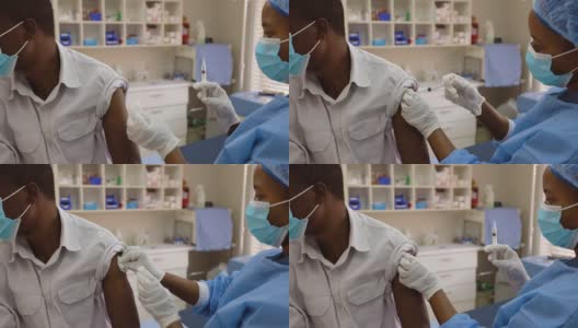 非洲黑人女医生为一名非洲黑人男性患者注射Covid-19疫苗高清在线视频素材下载