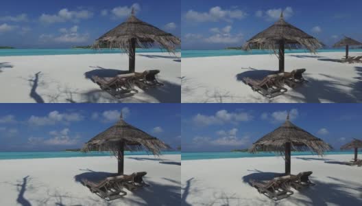 马尔代夫海滩上的帕拉帕和日光浴床高清在线视频素材下载