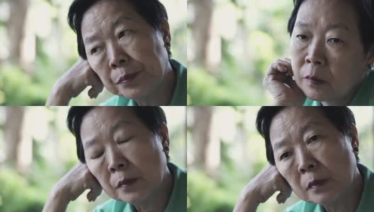 视频中亚洲资深女性手放在脸上思考，担心和悲伤高清在线视频素材下载