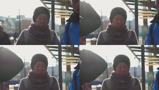 一对亚裔老年夫妇在阿姆斯特丹等电车。退休后自己环游世界高清在线视频素材下载