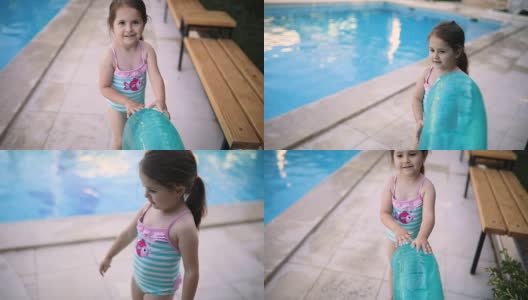 漂亮的幼童在游泳池里玩一个游泳圈高清在线视频素材下载
