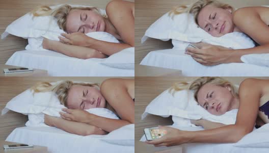 年轻女子在床上醒来，手机上的闹钟正在打盹高清在线视频素材下载