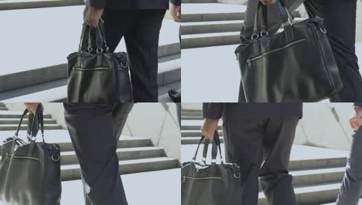 男士西装手拿皮制公文包，奢华商务风格，品牌配饰高清在线视频素材下载