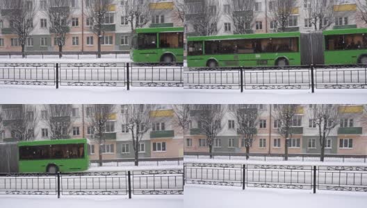 公共汽车行驶的背景是城市里的一座老建筑。下雪，冬天，慢镜头高清在线视频素材下载