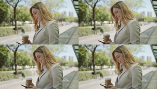 年轻漂亮的女商人用她的智能手机发短信等公交车，享受着外卖咖啡高清在线视频素材下载
