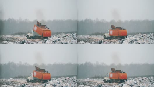 一辆橙色卡车在垃圾场清理垃圾。高清在线视频素材下载