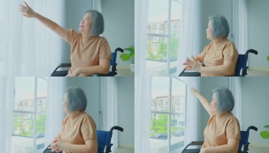 亚洲年长的残疾妇女坐在轮椅上，打开窗户。在敬老院，孤独的老奶奶病人感到快乐，享受着清晨的日出。医院保健和医疗高清在线视频素材下载