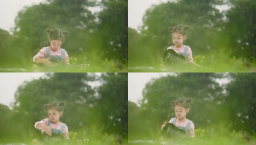 女孩在公园里玩尤克里里野餐高清在线视频素材下载