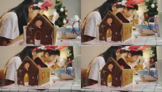 亚洲的孩子们晚上在家里一起做姜饼屋，庆祝圣诞节的生活理念。高清在线视频素材下载
