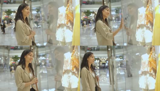年轻的亚洲女人看在一个商店橱窗与手表和奢侈品在购物中心高清在线视频素材下载