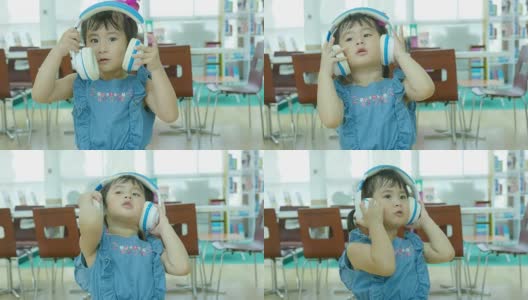 一个亚洲女孩戴着耳机唱歌听音乐高清在线视频素材下载