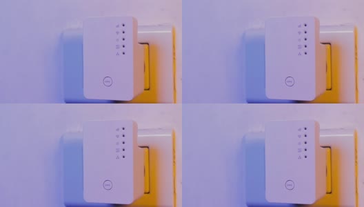男子将手指按在WiFi中继器的WPS按钮上，该按钮位于墙上的电源插座上高清在线视频素材下载