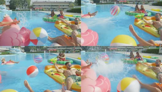 慢镜头:快乐的年轻人在五颜六色的浮子上戏水高清在线视频素材下载