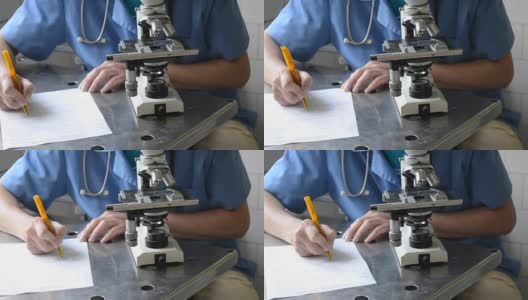 医生用显微镜在纸上记录信息高清在线视频素材下载