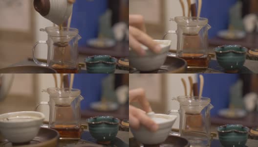 用手将沏好的绿茶倒入有滤纸的玻璃茶壶中高清在线视频素材下载