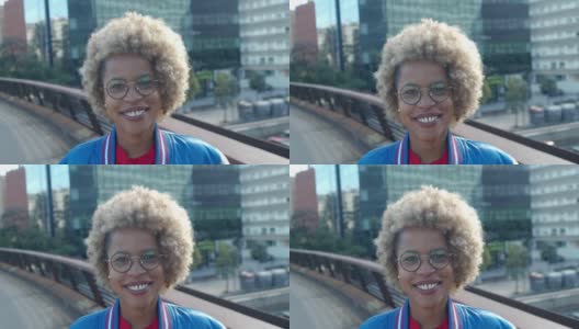 非洲裔美国妇女，一头非洲式发型，在一个城市里看着镜头高清在线视频素材下载