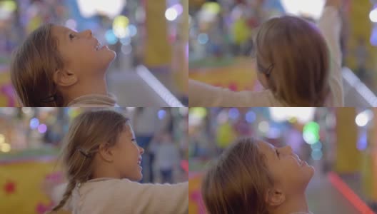 一个快乐的小女孩(孩子)微笑着在Luna公园玩耍的肖像。理念:幸福、自由、乐趣、家庭高清在线视频素材下载