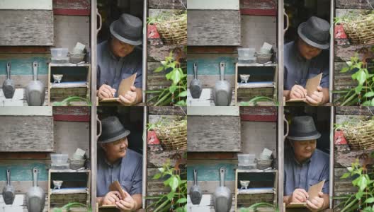 早上，亚洲男人在古董窗边写日记。高清在线视频素材下载