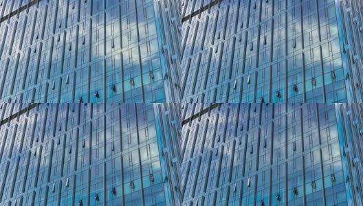 在蓝色的天空中有玻璃幕墙的现代蓝色建筑高清在线视频素材下载