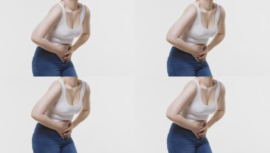 腹部疼痛的妇女，腹部疼痛的白色背景高清在线视频素材下载