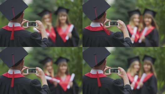 年轻的毕业生在斗篷和帽子上拍照的女孩在手机上，友谊高清在线视频素材下载