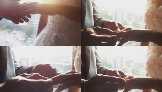 在婚礼那天，新郎把结婚戒指戴在新娘的手指上。高清在线视频素材下载