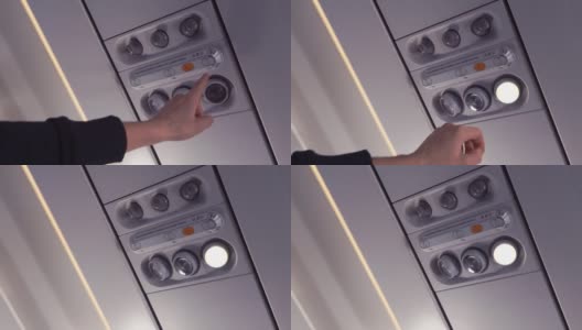 乘客的手打开飞机上的灯。特写镜头。高清在线视频素材下载