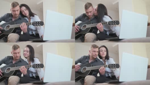 年轻夫妇坐在家里的沙发上用笔记本电脑在线学习弹吉他高清在线视频素材下载