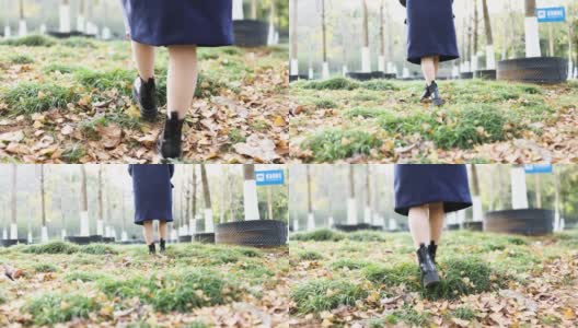 秋天，一个女人走在公园地上的黄叶上。高清在线视频素材下载