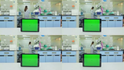 平板绿色屏幕背景与科学家在实验室工作高清在线视频素材下载