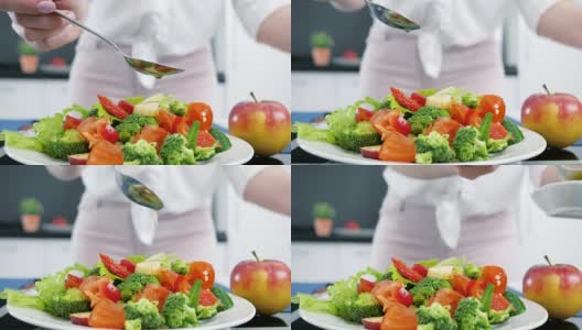 适当的营养，把橄榄油倒在蔬菜上，厨房里的新鲜有机沙拉高清在线视频素材下载