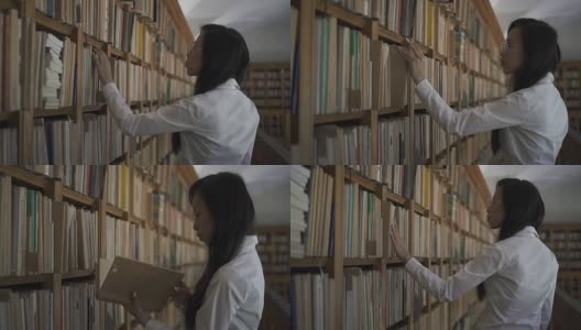 穿着白衬衫的年轻亚洲生物学家学生从书架上拿旧书高清在线视频素材下载