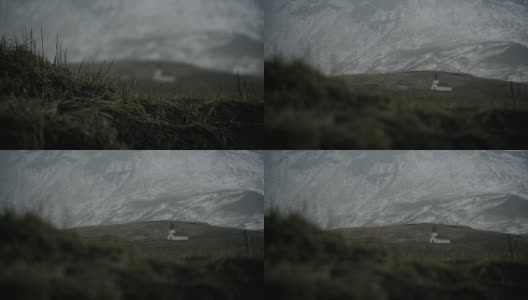 聚焦架从雪场和暴风雪在山上小教堂，冰岛，维克高清在线视频素材下载
