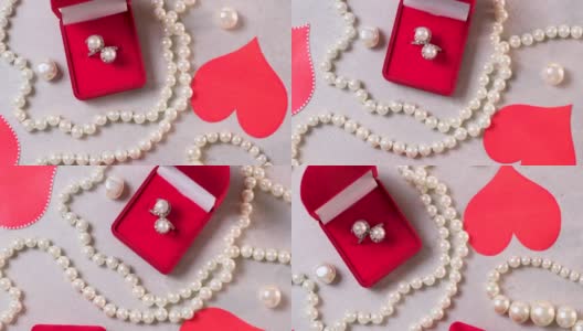 红盒子里的金戒指和珍珠。情人节的浪漫背景有宝石、礼物、订婚戒指等。求婚、婚礼或节日礼物的概念。贺卡旋转高清在线视频素材下载