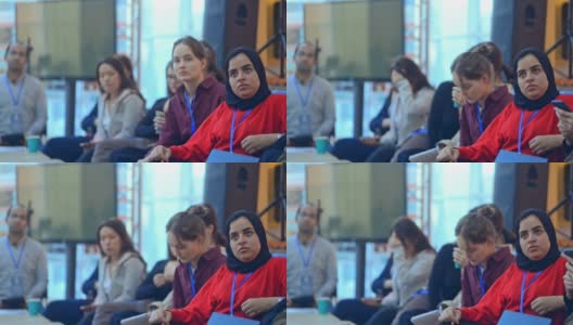 在irl研讨会上，女人会倾听演讲者的演讲。国际女性佩戴徽章高清在线视频素材下载