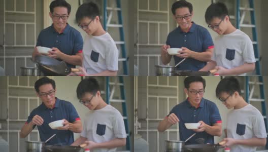 周末，一位亚洲华人父亲在自家后院的厨房教儿子做饭，准备晚餐高清在线视频素材下载