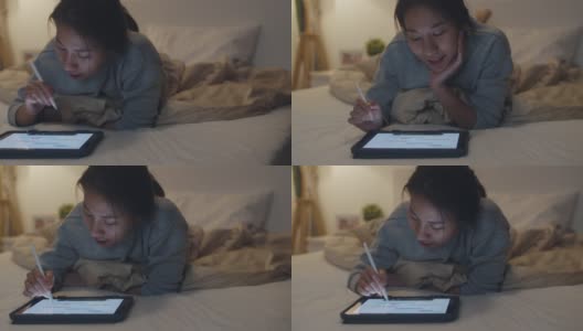 自由亚洲妇女休闲穿着使用笔记本电脑努力工作在床上在卧室在家里晚上。高清在线视频素材下载