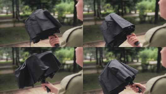 一个女人抖掉伞上的雨滴高清在线视频素材下载