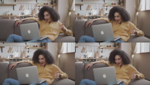惊讶的非洲裔美国女士非常惊讶地看着她的笔记本电脑高清在线视频素材下载