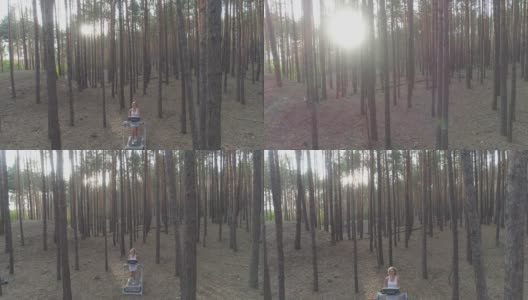 空中镜头。一名年轻女子在森林里的跑步机上跑步。高清在线视频素材下载