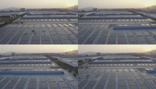 太阳落山时，太阳能电池板安装在一家大型工厂的屋顶上的航拍照片高清在线视频素材下载