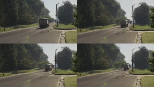 半挂车在树木繁茂的道路上超速行驶高清在线视频素材下载