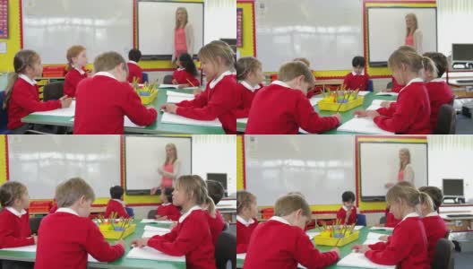 学生围坐在桌子旁，老师站在白板旁高清在线视频素材下载