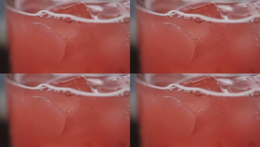 粉红色的柠檬水饮料在玻璃杯与冰块高清在线视频素材下载