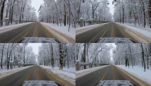 汽车行驶在冰雪覆盖的公路上，沿途是冬日的森林高清在线视频素材下载