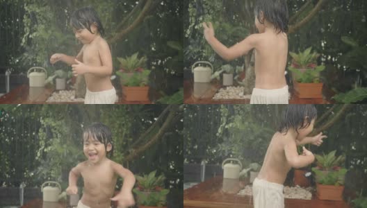亚洲婴儿在自家前院笑着玩水。高清在线视频素材下载