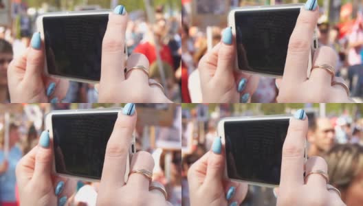 在庆祝胜利日期间，女人的手在手机上做一个视频的特写高清在线视频素材下载