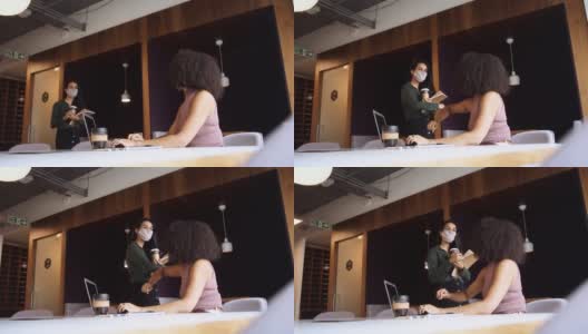 在健康大流行期间，两个戴着面具的女商人在办公室用手肘碰触来打招呼——用慢镜头拍摄高清在线视频素材下载