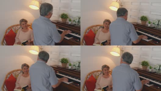 4K亚洲老夫妇一起在家里的客厅里弹钢琴和唱歌。高清在线视频素材下载